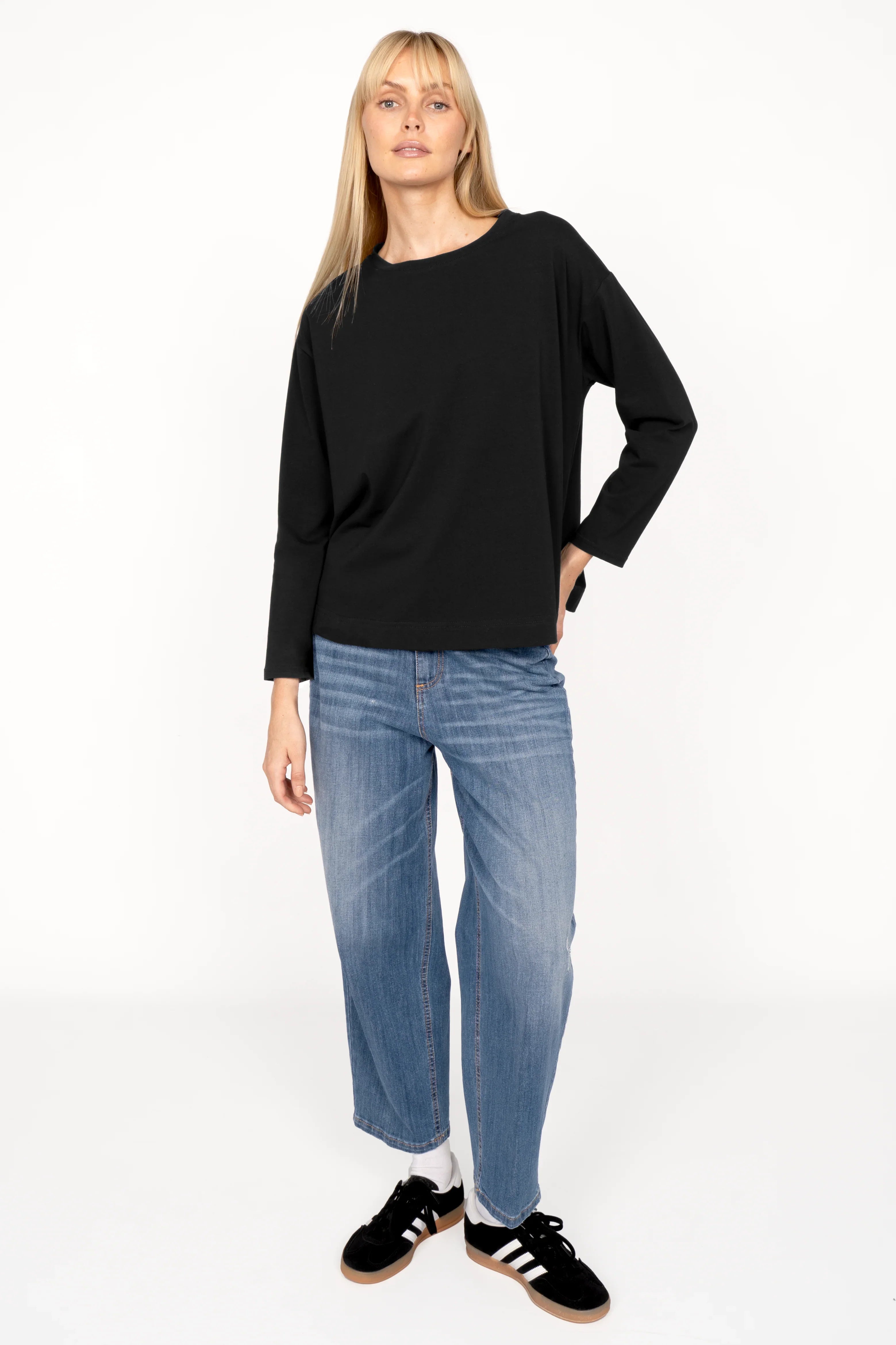 NITI.K Langarm Shirt black long sleeve relaxed fit cotton jersey with round neckline and side slits modeled with blue jeans and black sneakers