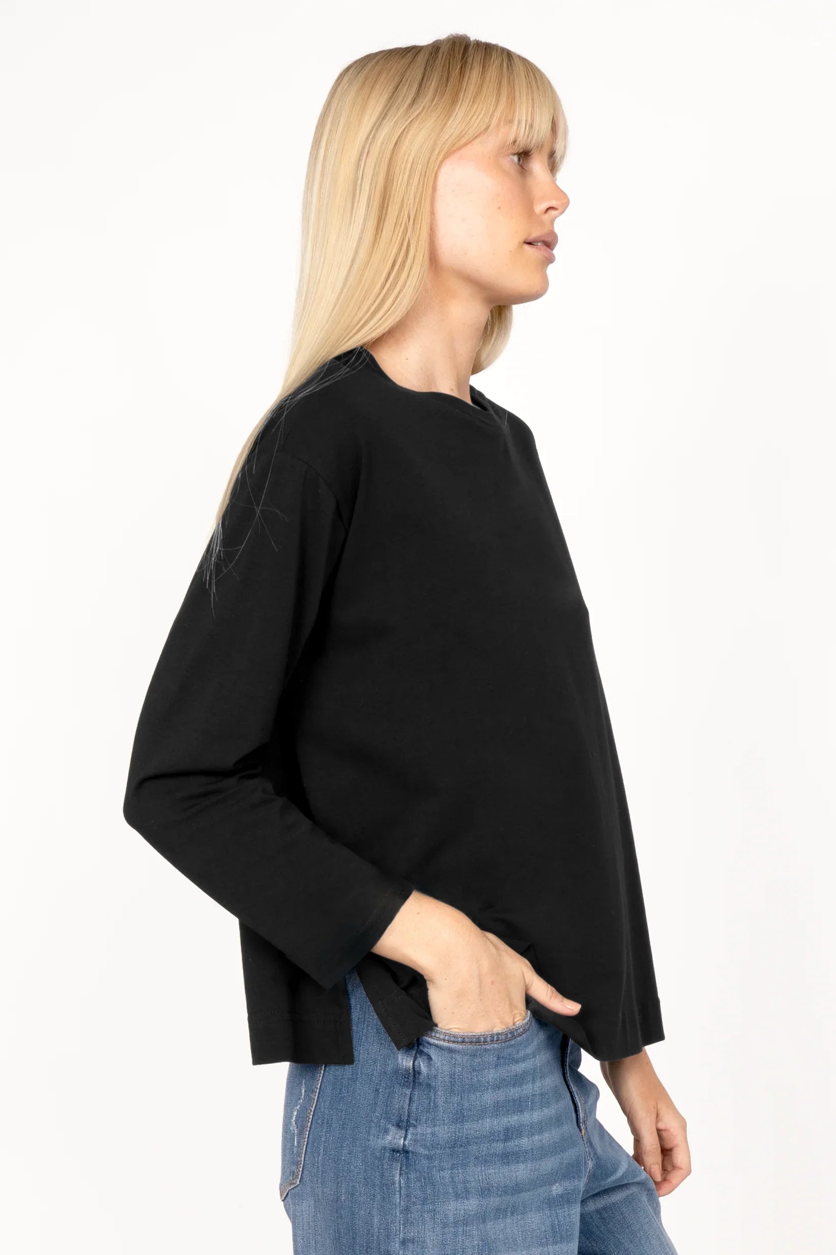 Black NITI.K Langarm Shirt with long sleeves, relaxed fit, round neckline, dropped shoulders, side slits, and boxy cut worn with blue jeans.