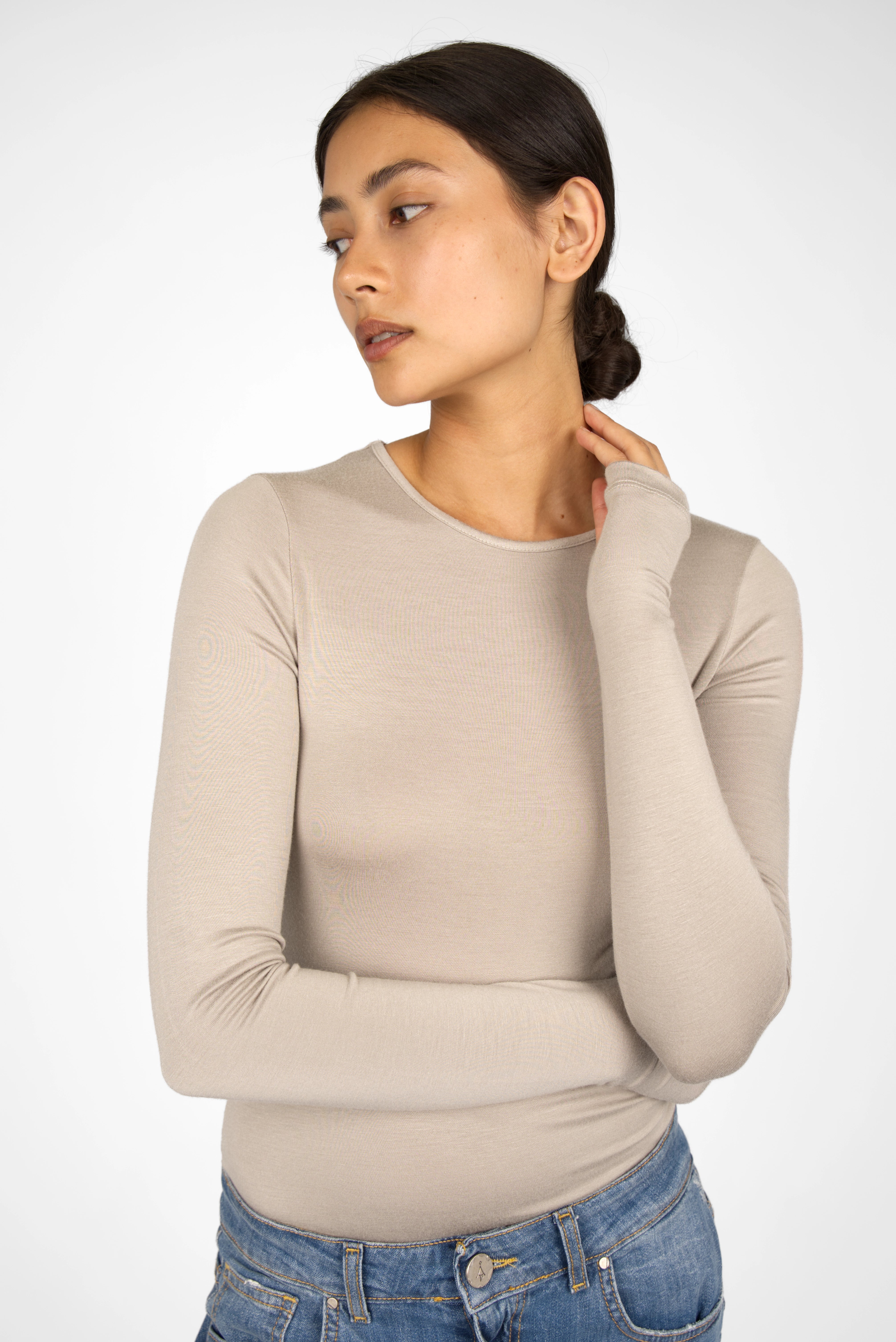 Woman wearing beige slim fit NJELI Longsleeve with round neckline and thumb holes in extra-long sleeves