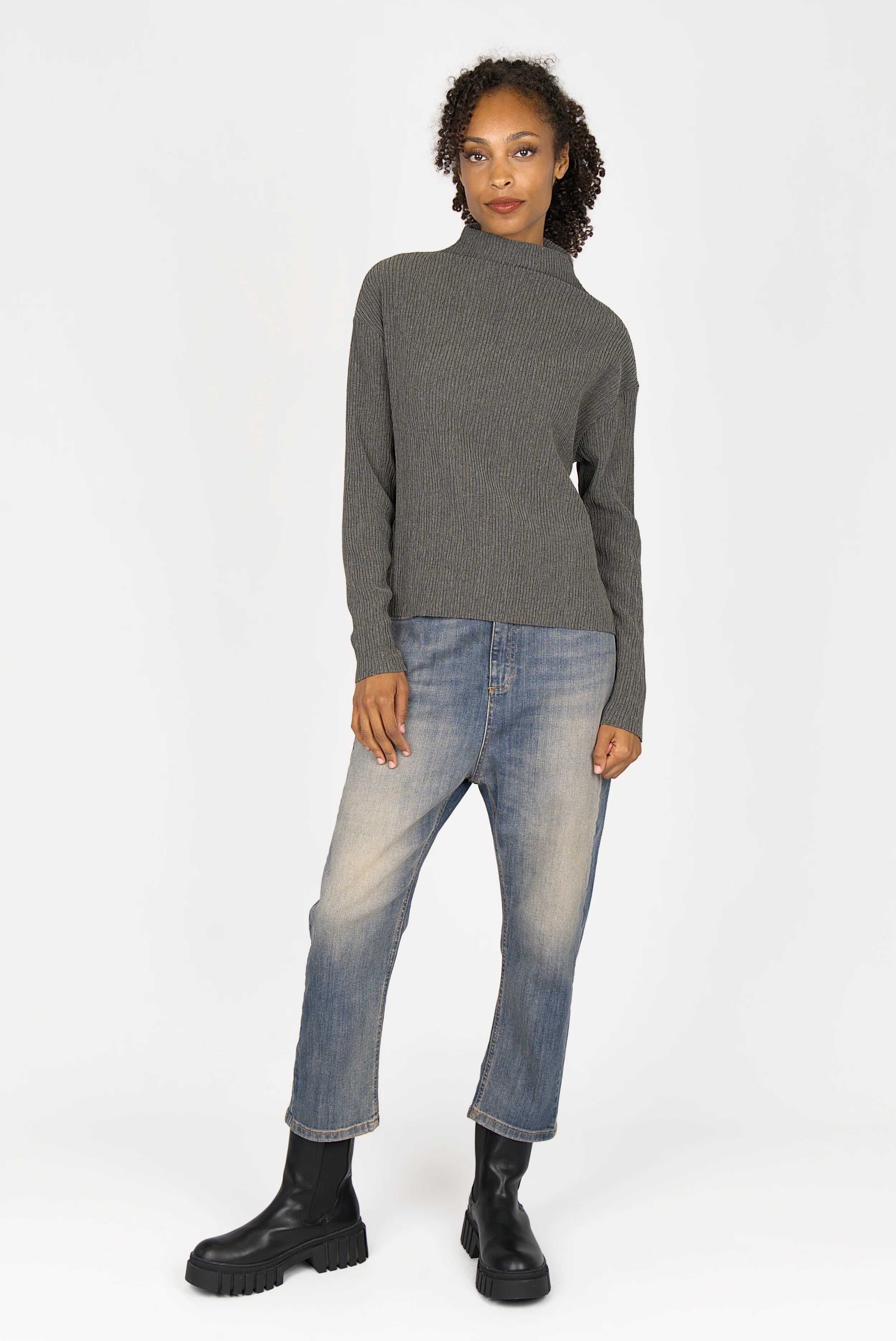 Woman wearing grey NORELI Longsleeve with mock neck and pleated crepe jersey fabric, paired with jeans and black boots