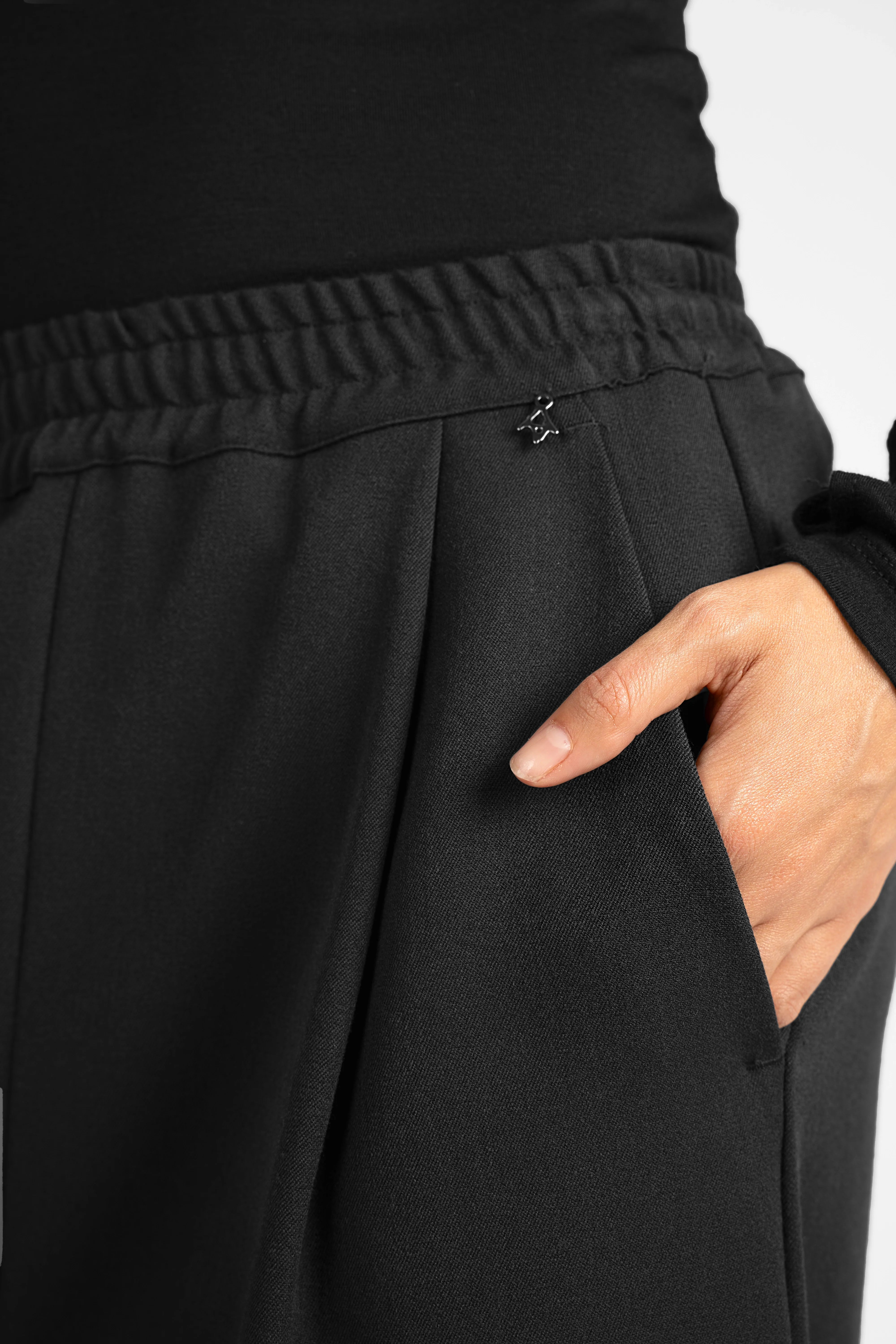 Close-up of black ONAH wide-leg hose with elastic waistband and side pocket detail
