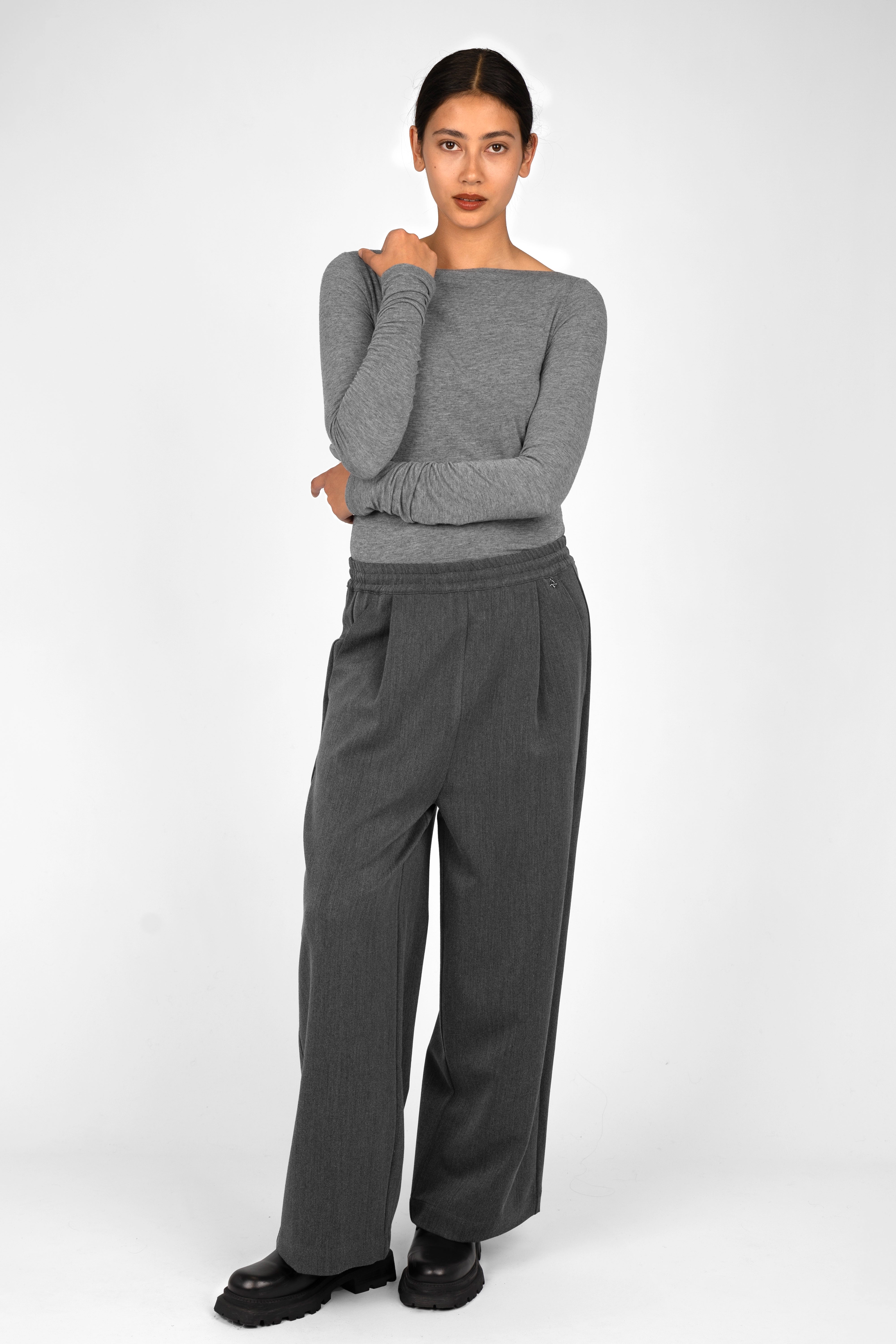 Woman wearing gray ONAH Wide-Leg Hose with elastic waistband and relaxed fit standing against white background