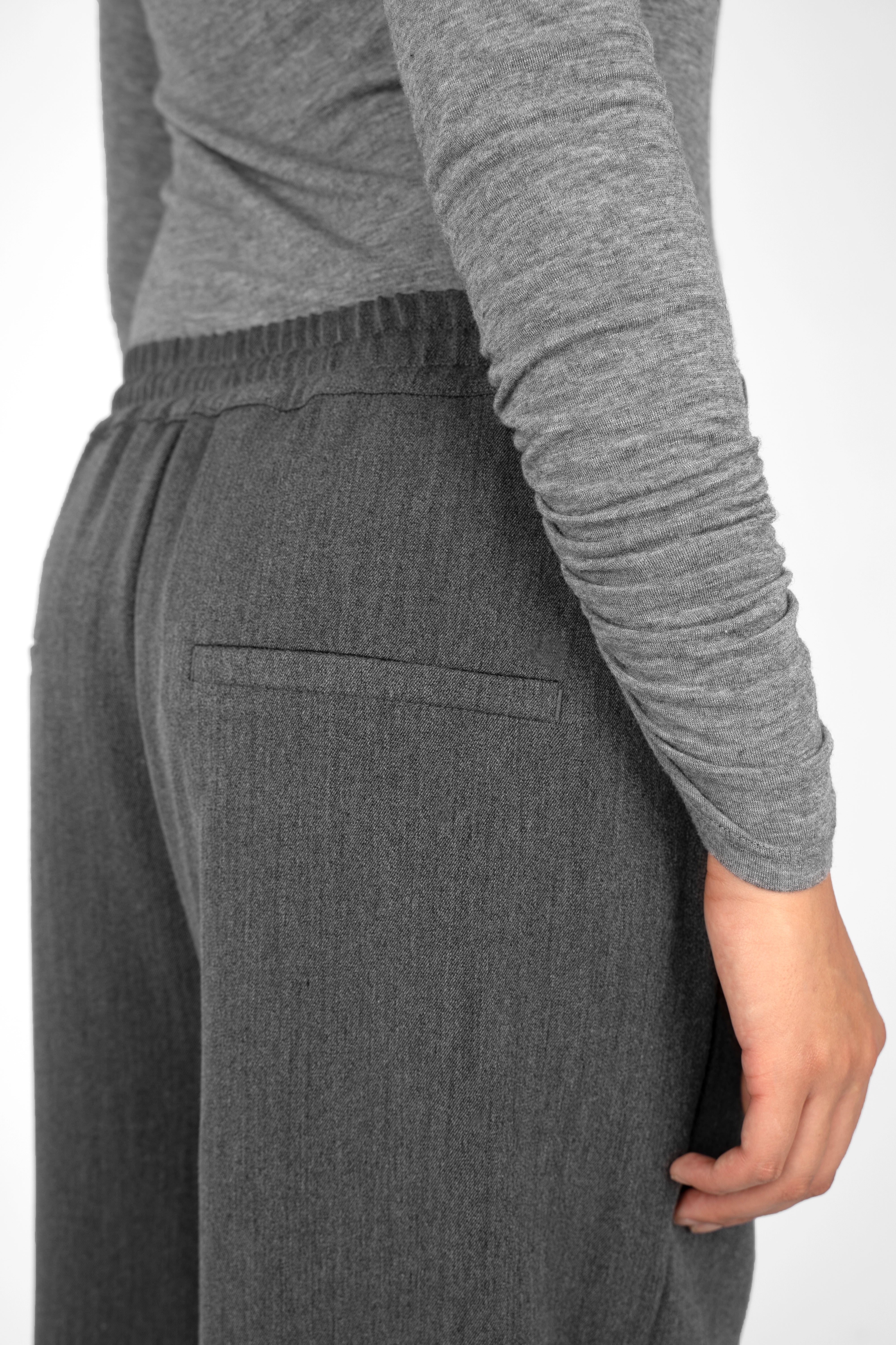 Back view of person wearing ONAH Wide-Leg Hose in dark grey with elastic waistband and side pockets