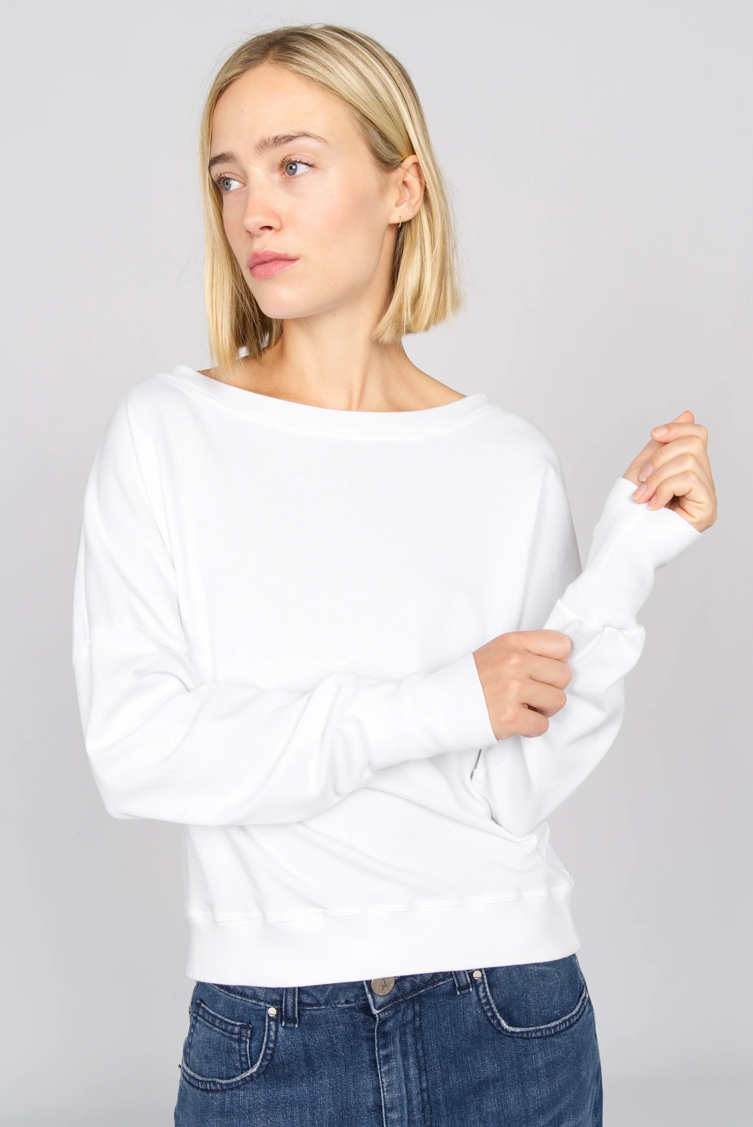 Weißes RIISA Longsleeve aus Baumwolljersey mit U-Boot Ausschnitt und überschnittenen Schultern bei Frau getragen