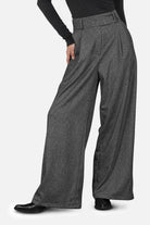 Damen trägt RYONI High Waist Marlenehose mit Fischgratmuster und weitem Bein