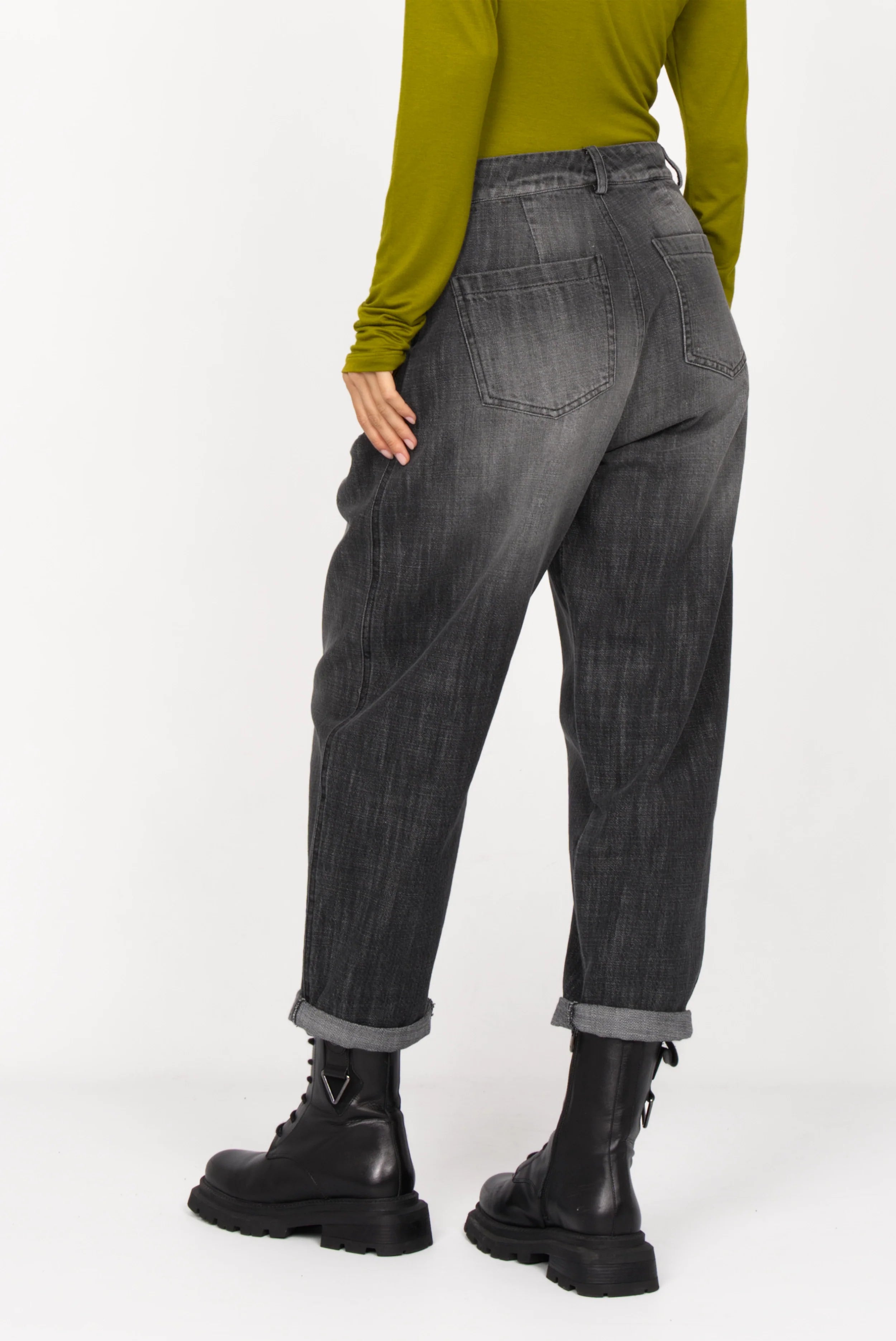 SAIKA Relaxed Tapered Hose in denim-look black wash with whisker details and relaxed fit worn with black boots and green top from back view