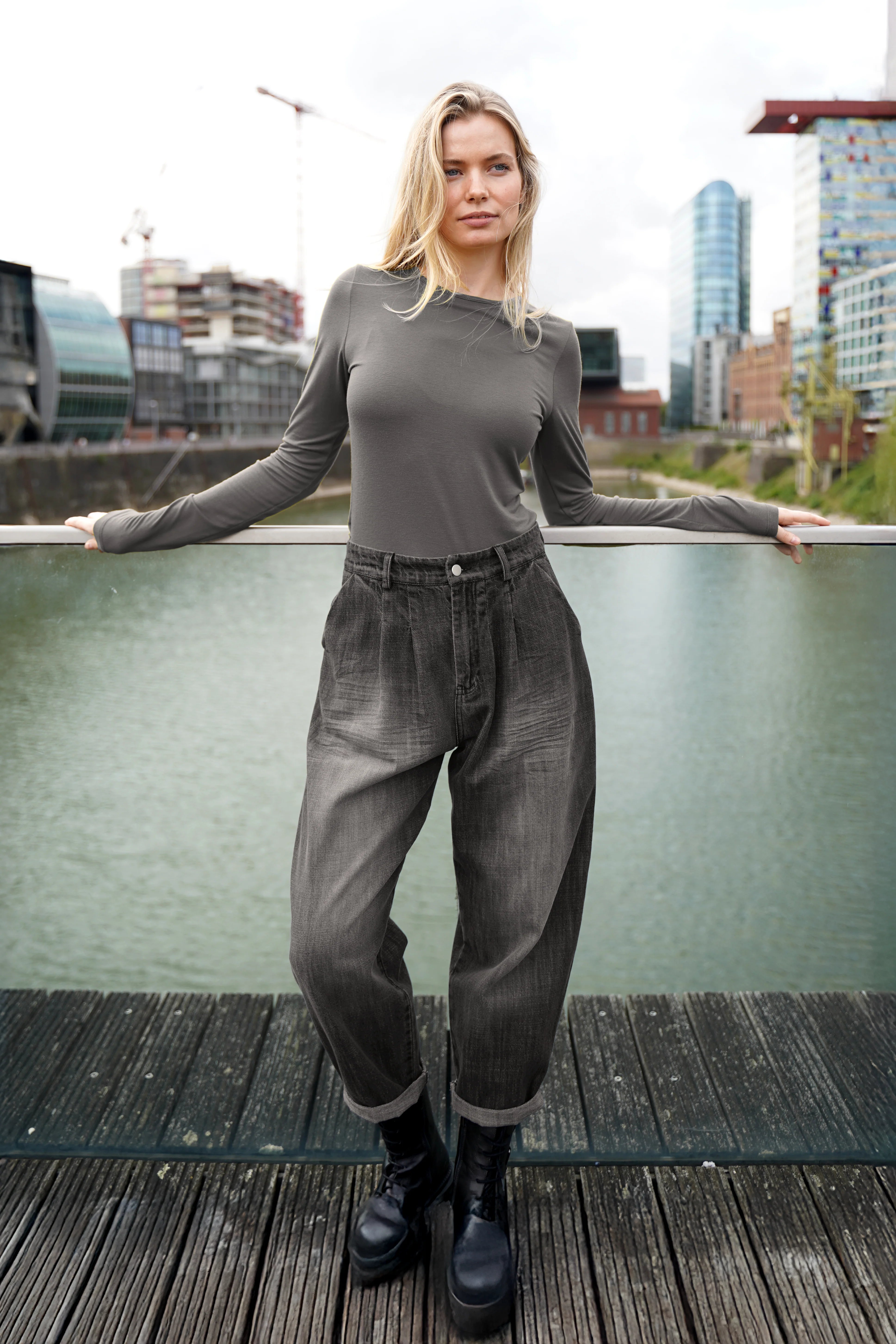 Damen trägt SAIKA Relaxed Tapered Hose in Washed Black mit lockerer Passform und dezenter Karottenform outdoor urban