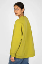 Lässiger SELKA Sweater in A-Linie mit Raglanärmeln, breiten Bündchen, schmalem Rundhalsausschnitt und tonaler Logo-Stickerei, hinten länger geschnitten.
