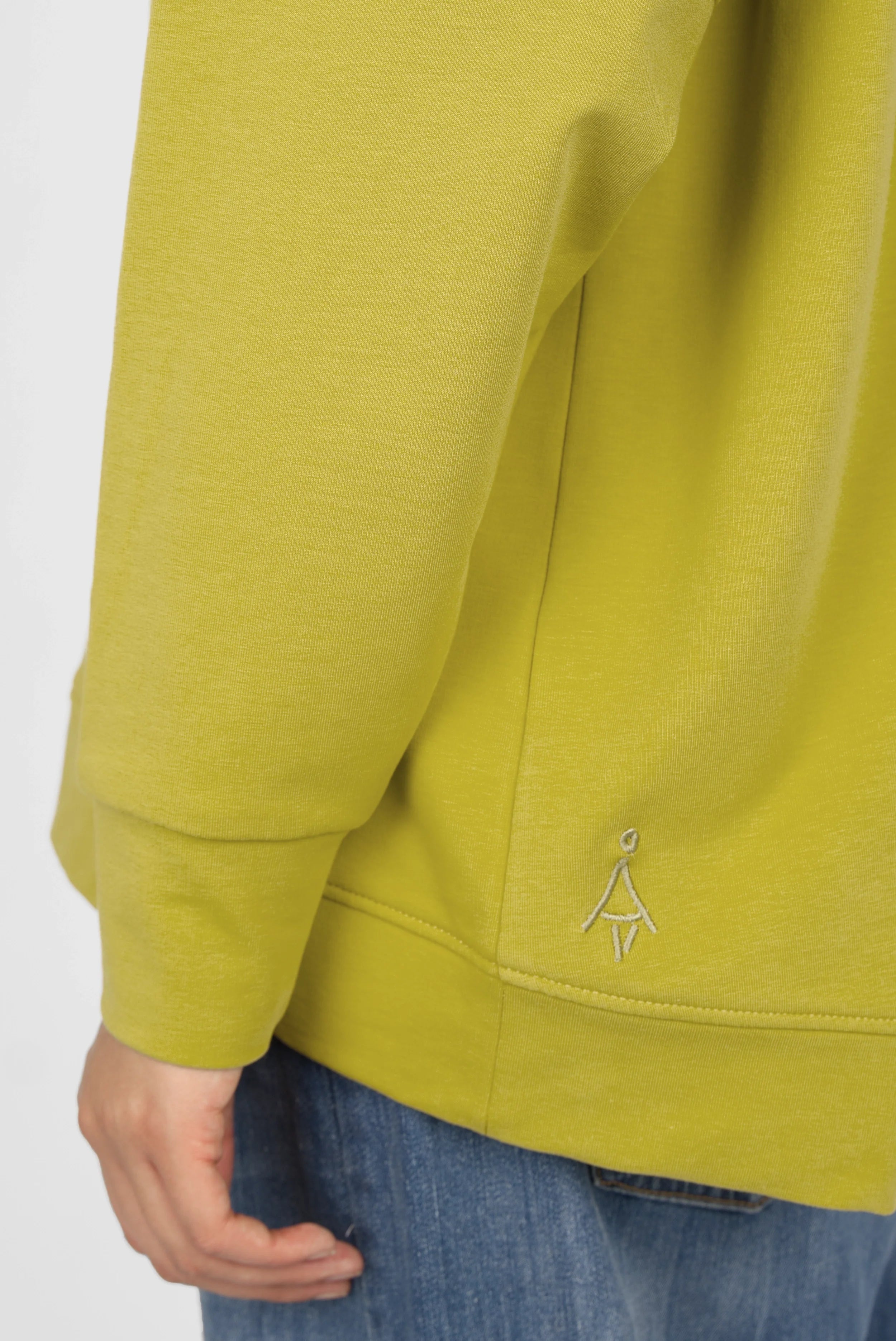 Grüner SELKA Sweater mit Raglanärmeln, breiten Bündchen und tonaler Logo-Stickerei, hinten länger geschnitten.