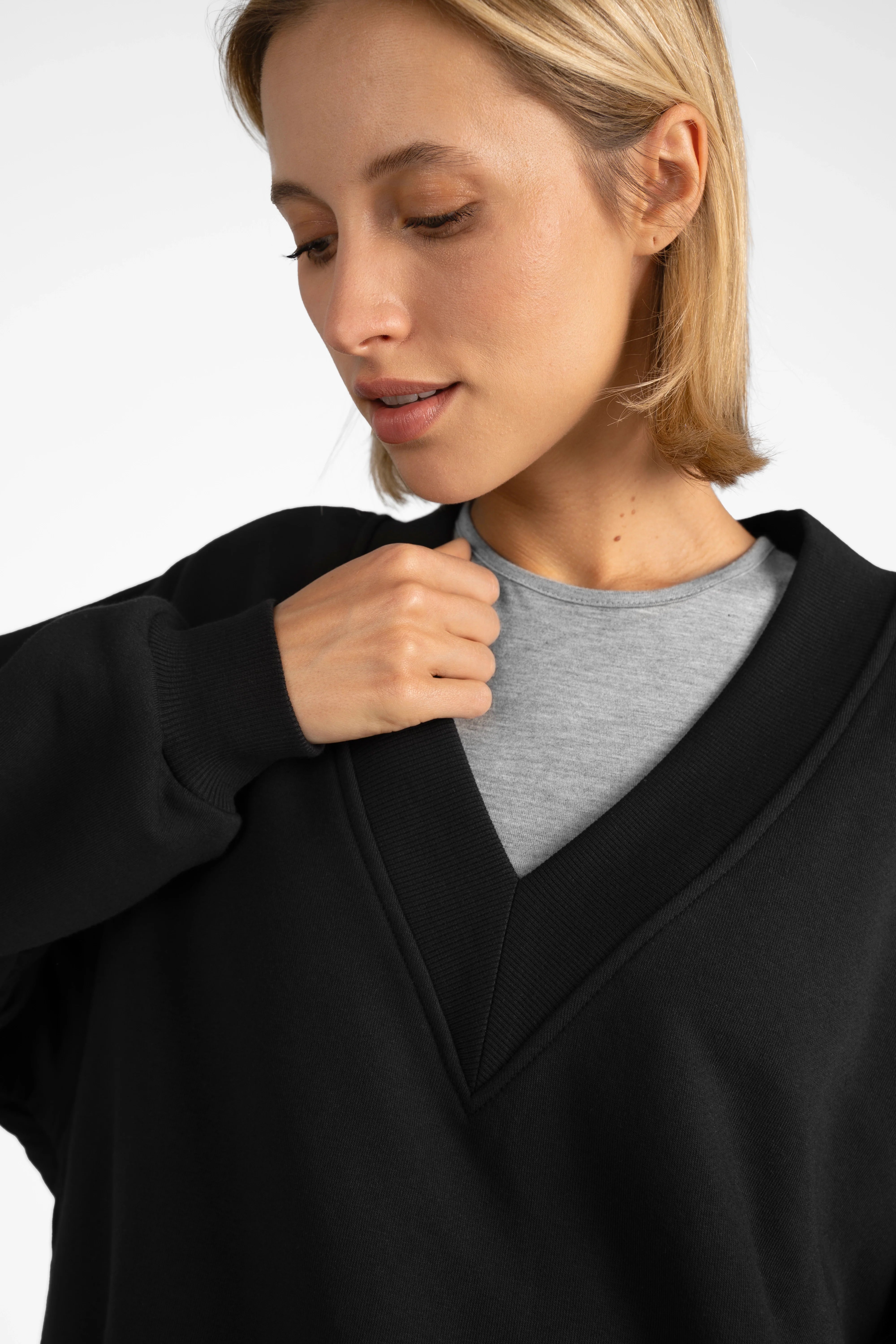 Woman wearing black SEREA Sweater mit V-Ausschnitt with deep V-neck, ribbed cuffs, and relaxed fit.