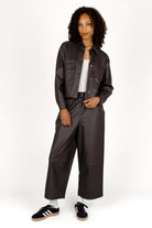 Woman wearing a cropped SOOAE shirt jacket made of supersoft eco-leather with kent collar and large chest pockets