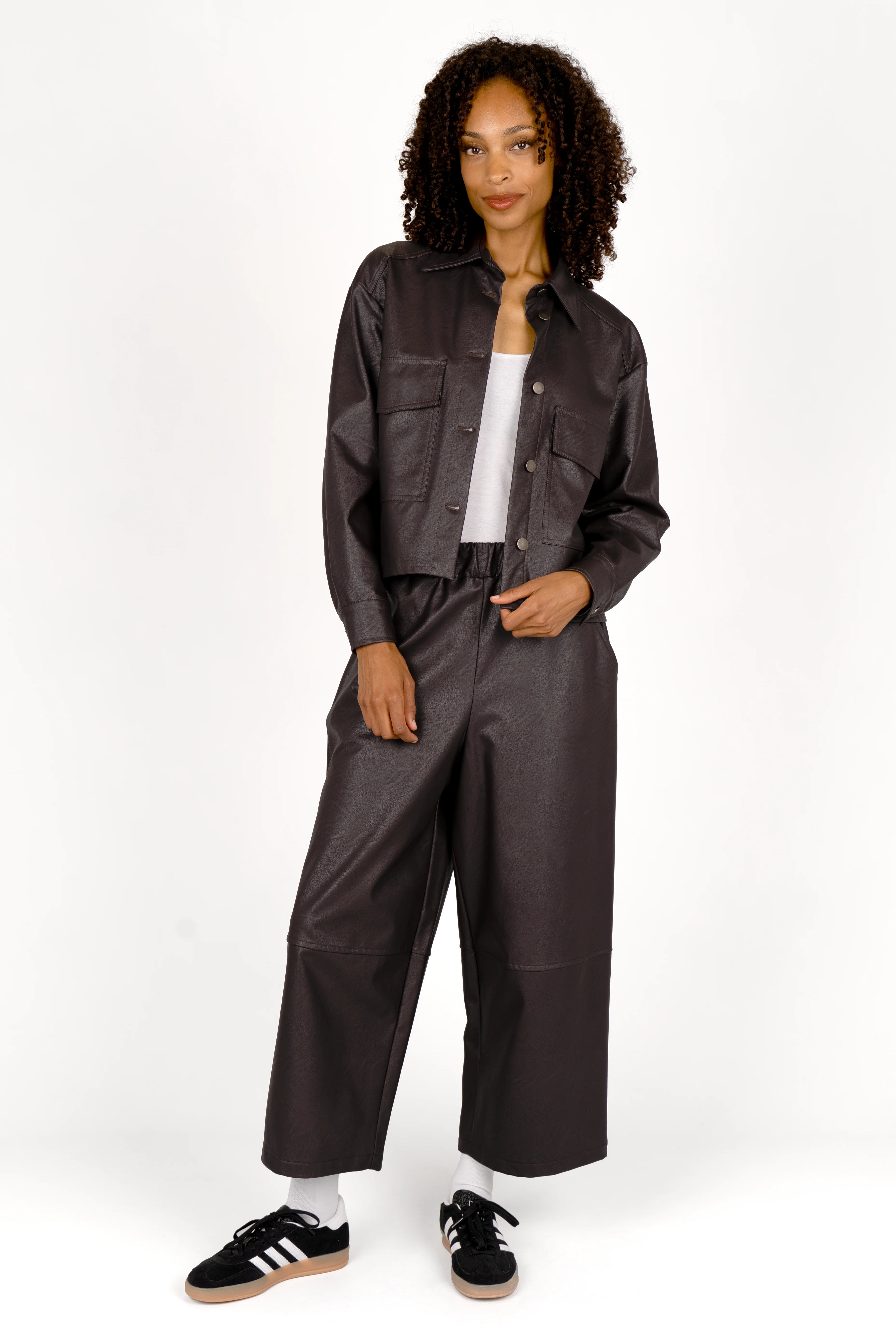 Woman wearing a cropped SOOAE shirt jacket made of supersoft eco-leather with kent collar and large chest pockets