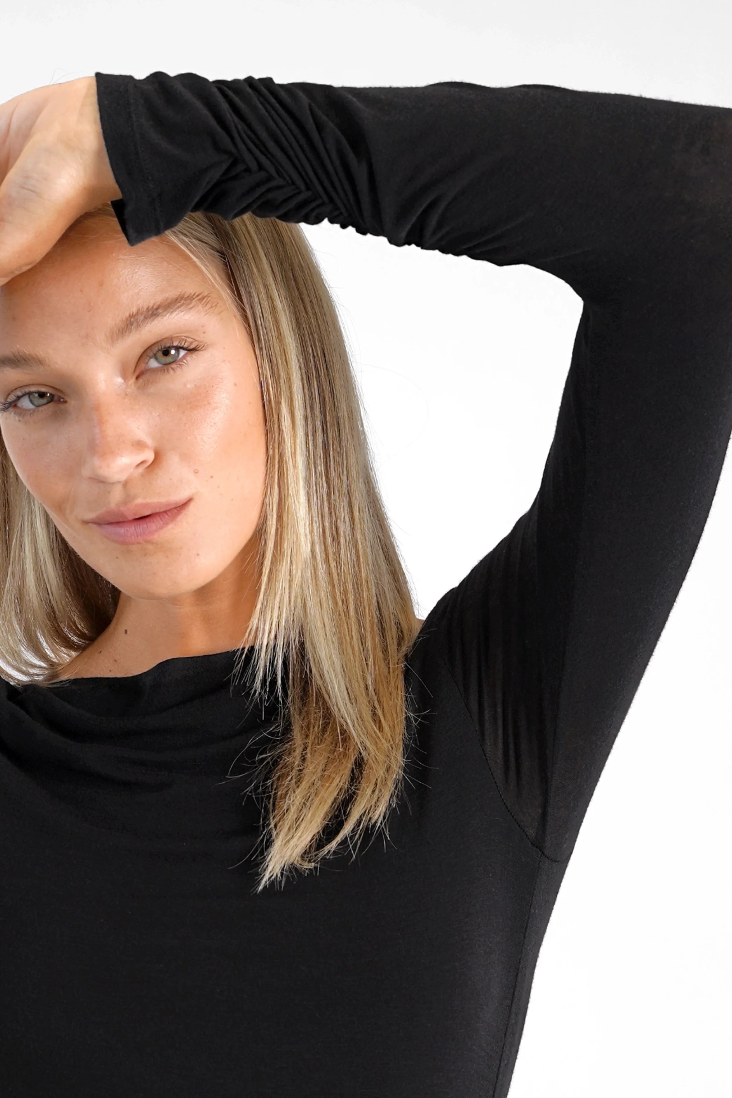 Woman wearing black SUJIN Longsleeve with U-boat neckline and ruched sleeves, slim fit cashmere blend top