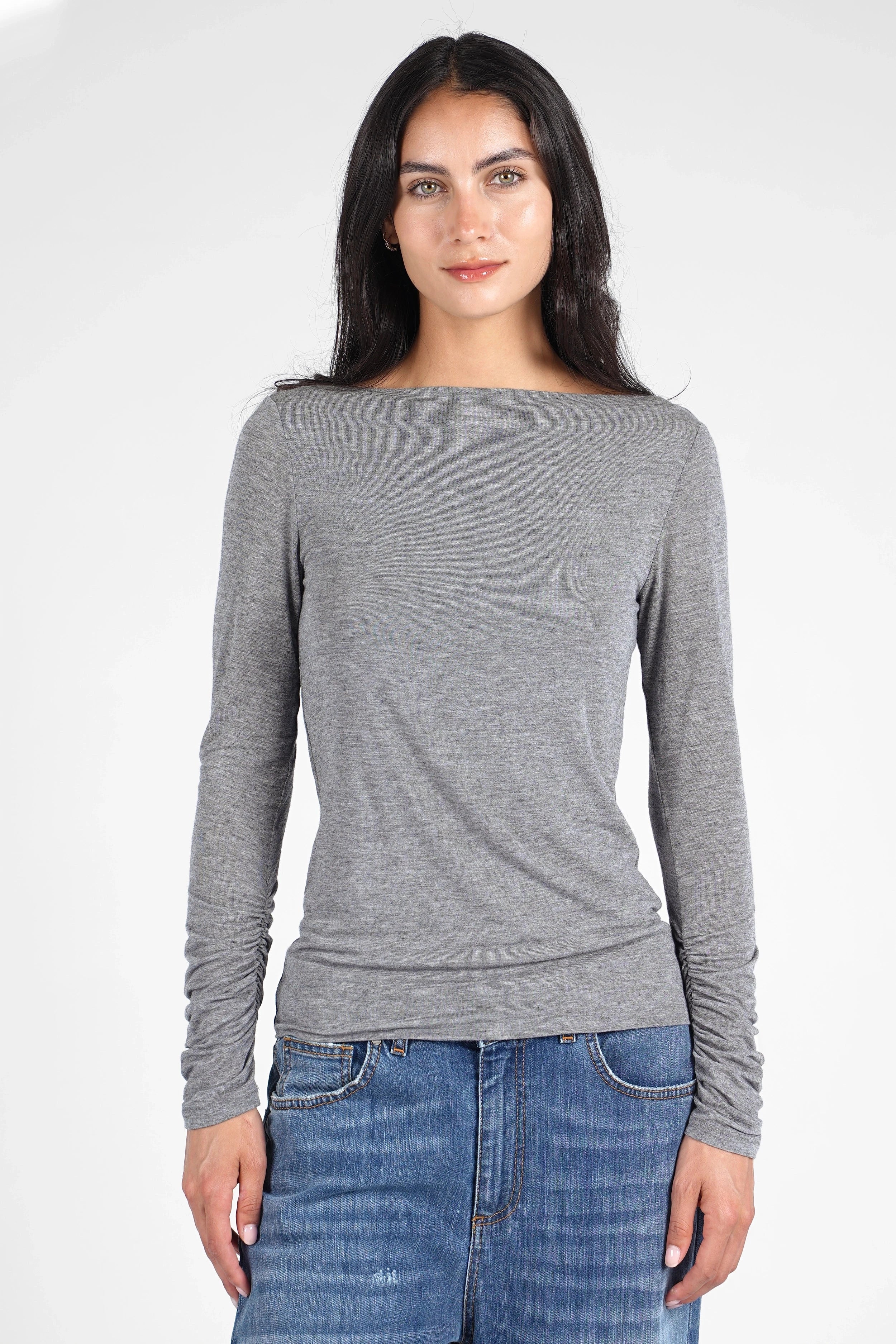 Woman wearing a grey slim fit SUJIN Longsleeve with U-boat neckline and ruched sleeves paired with blue jeans
