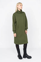 SYNNI Kleid olive green viscose-jersey dress with kangaroo pocket and relaxed fit worn with black boots