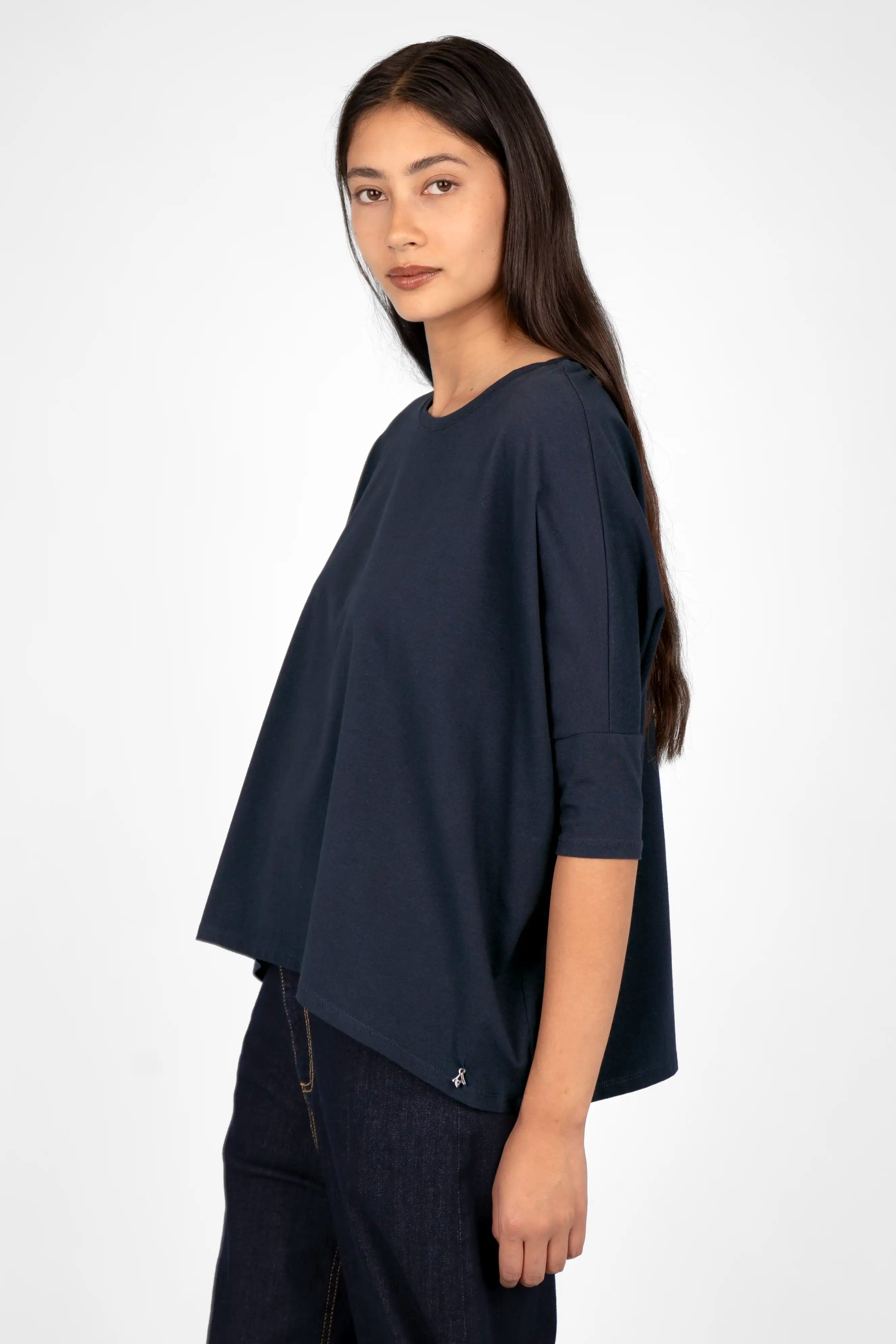 Damen trägt locker fallendes TAMI.K Blusenshirt in navyblau mit Rundhals, Relaxed Schnitt und weiter Kastenform.