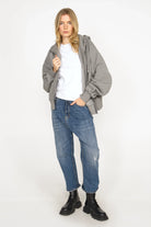 weißes TASYA Shirt aus softem Ripp-Jersey mit Slim Fit und Ziernähten, getragen von Model mit grauer Jacke und blauen Jeans