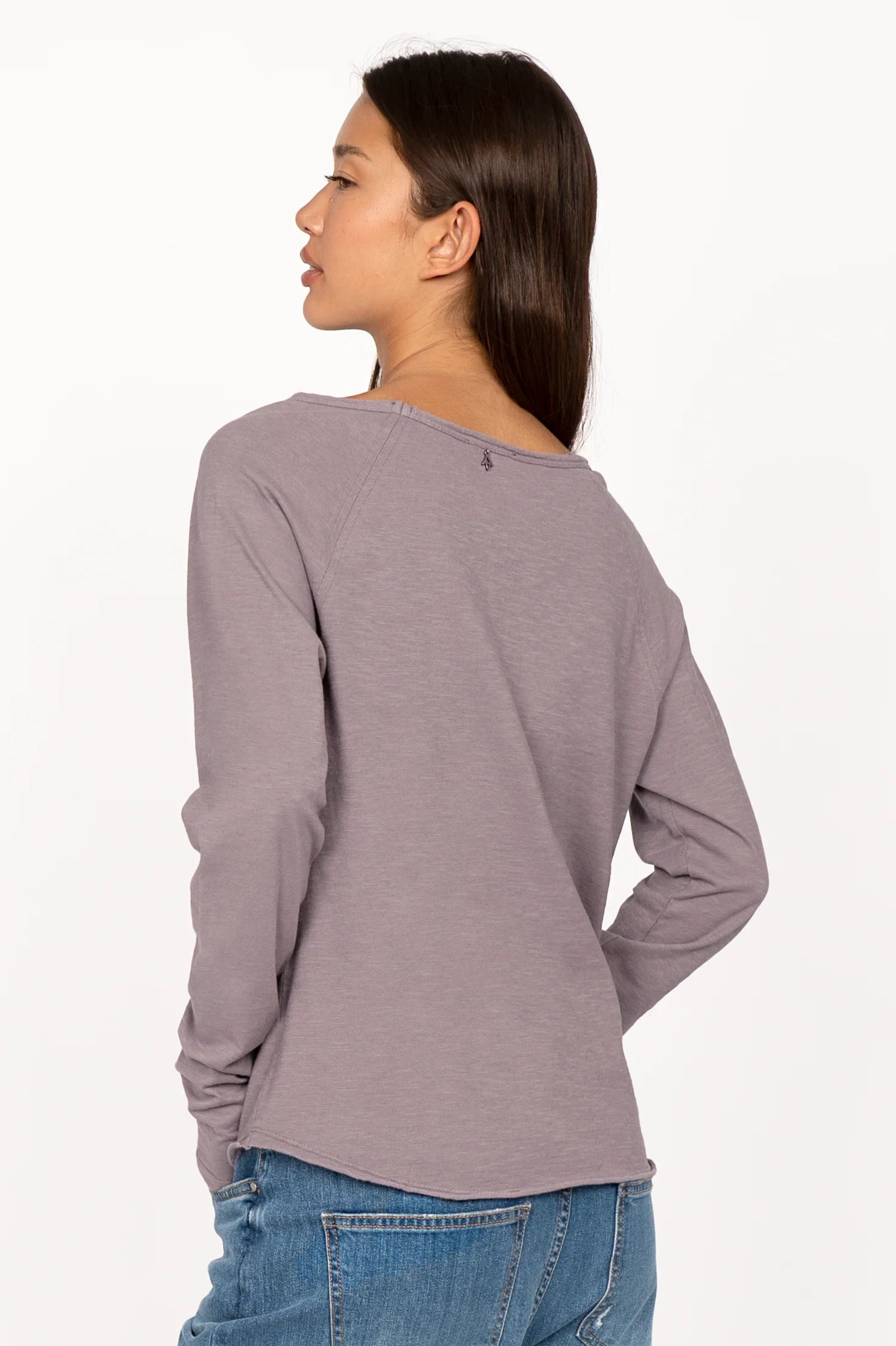 Woman wearing a grey TEHI Longsleeve with extralong raglan sleeves and open edge round neckline, shown from the back.