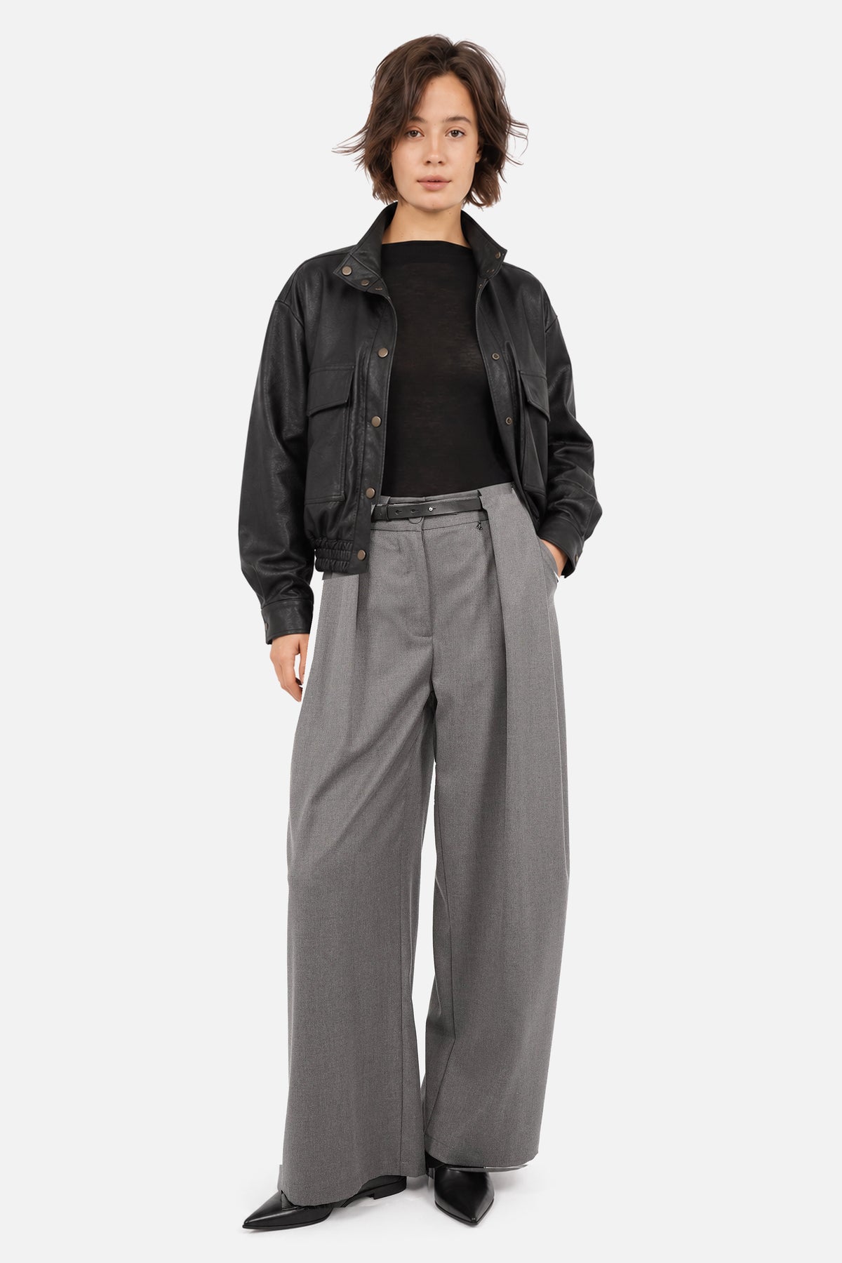THIRA grey pleated trousers with a belt, styled with a DERA Black jacket and black pointed-toe ankle boots
