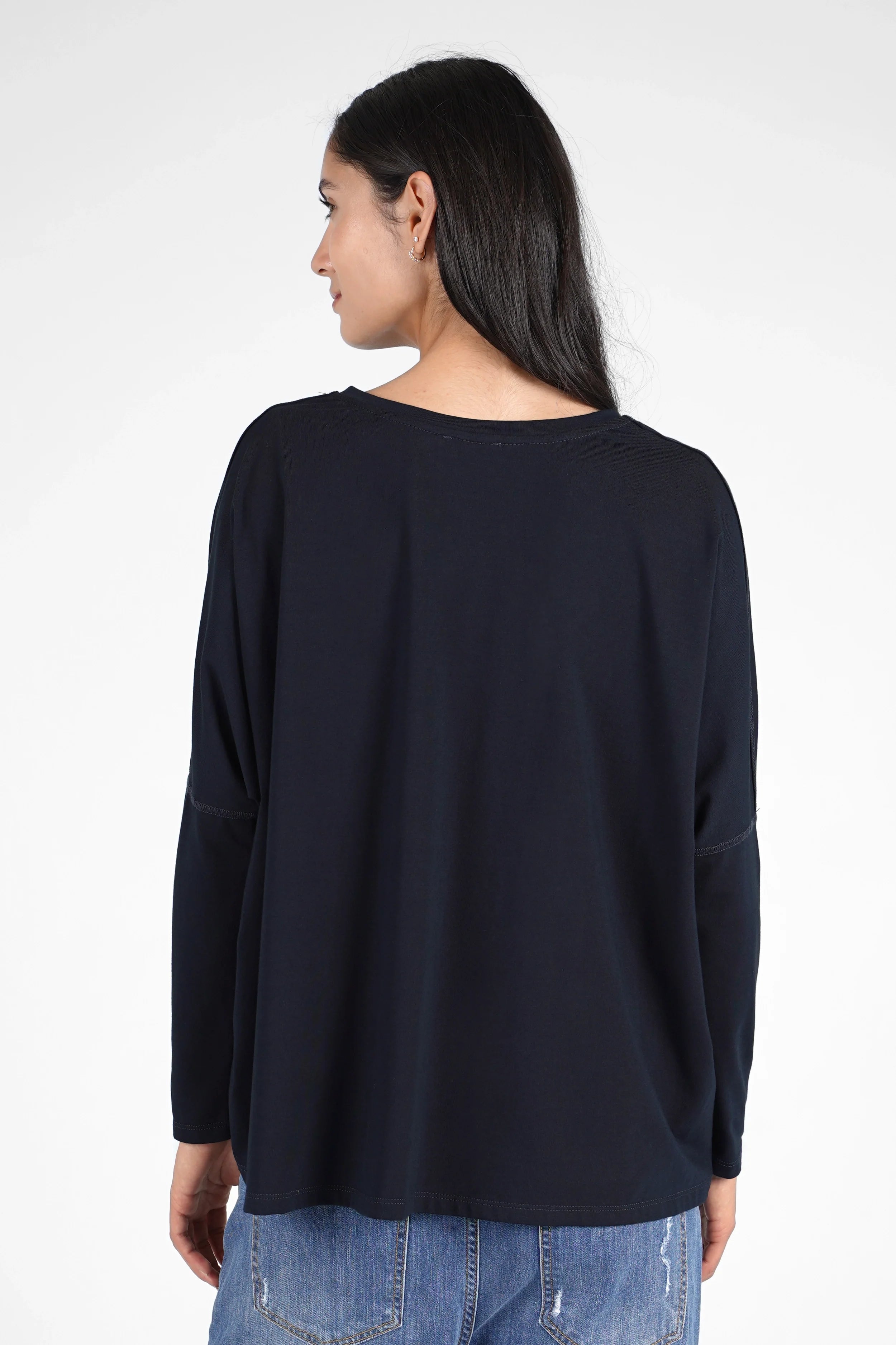 Woman wearing a navy blue TIDA Blusenshirt with long sleeves and a relaxed, boxy fit shown from the back.