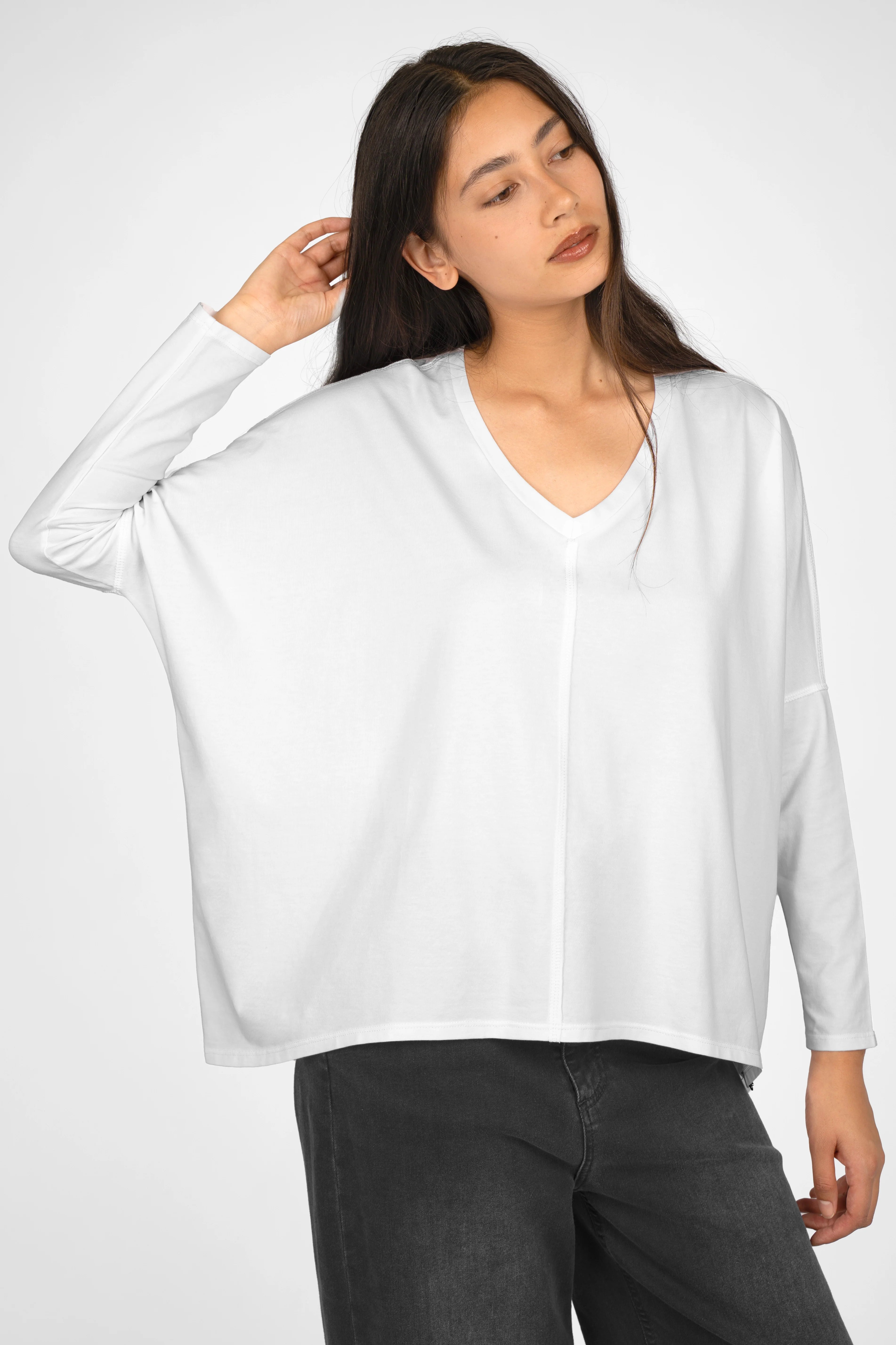 Woman wearing white TIDA Blusenshirt Langarm with V-neck and relaxed fit.