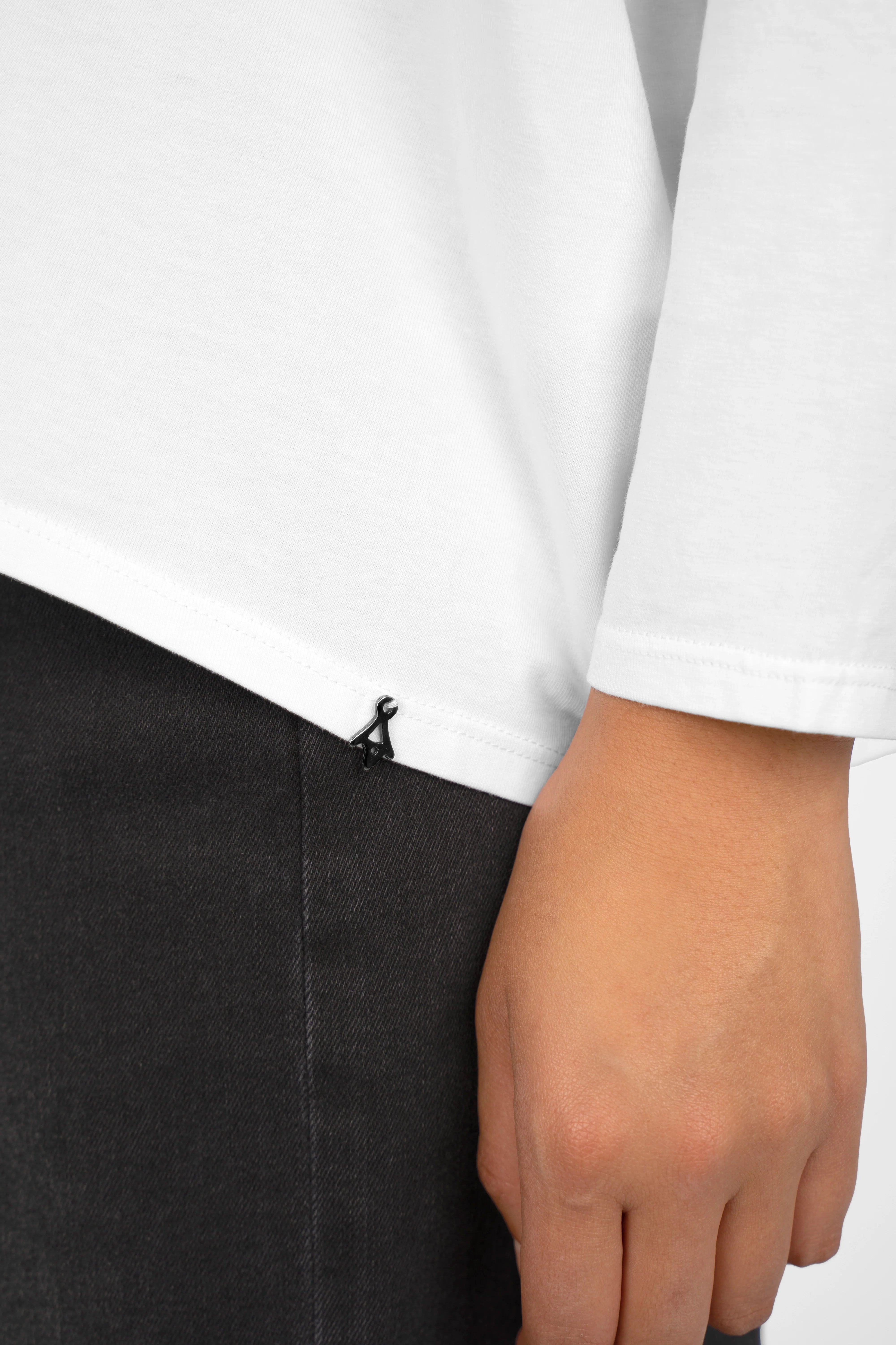 Close-up of a white TIDA Blusenshirt Langarm with relaxed fit and V-neck detail on a model's arm and hip.
