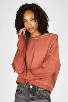 Frau trägt TIMAJ Revive One Shoulder Sweater mit weitem Rundhalsausschnitt und Vintage-Waschung in Mocha