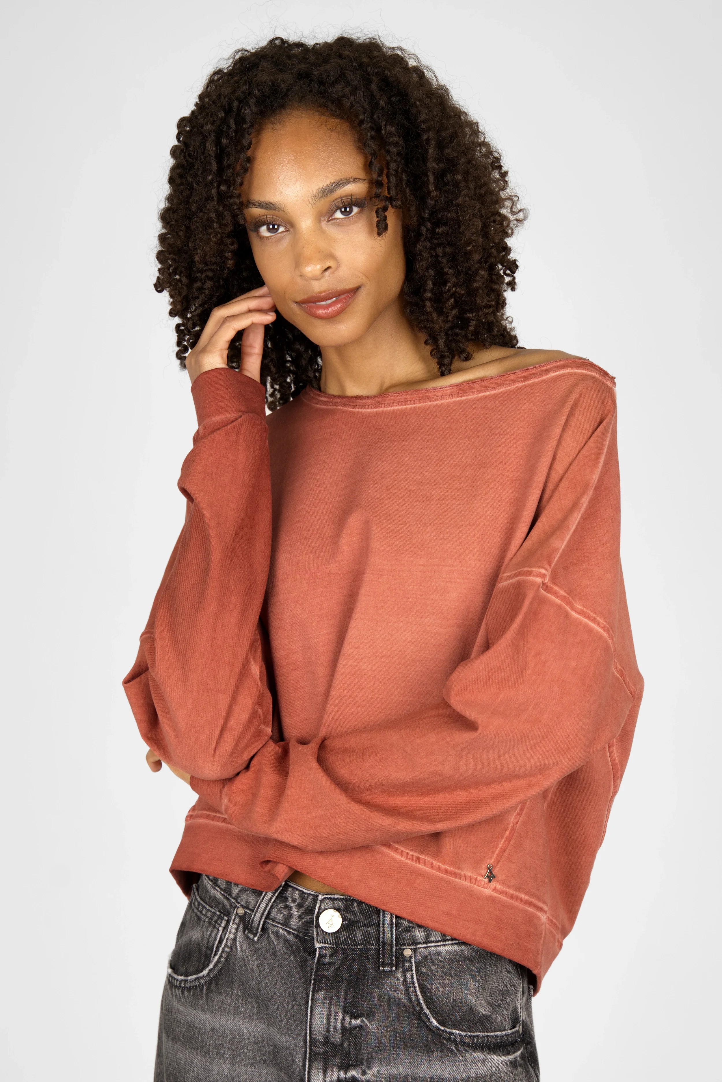 Frau trägt TIMAJ Revive One Shoulder Sweater mit weitem Rundhalsausschnitt und Vintage-Waschung in Mocha