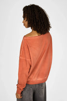 Woman wearing orange TIMAJ Revive One Shoulder Sweater with relaxed fit and wide neckline showing from the back