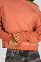 TIMAJ Revive One Shoulder Sweater in washed terracotta with loose fit and wide neckline showing one shoulder