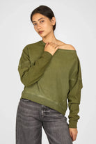 Woman wearing olive green TIMAJ Revive One Shoulder Sweater with relaxed fit and wide neckline showing one shoulder