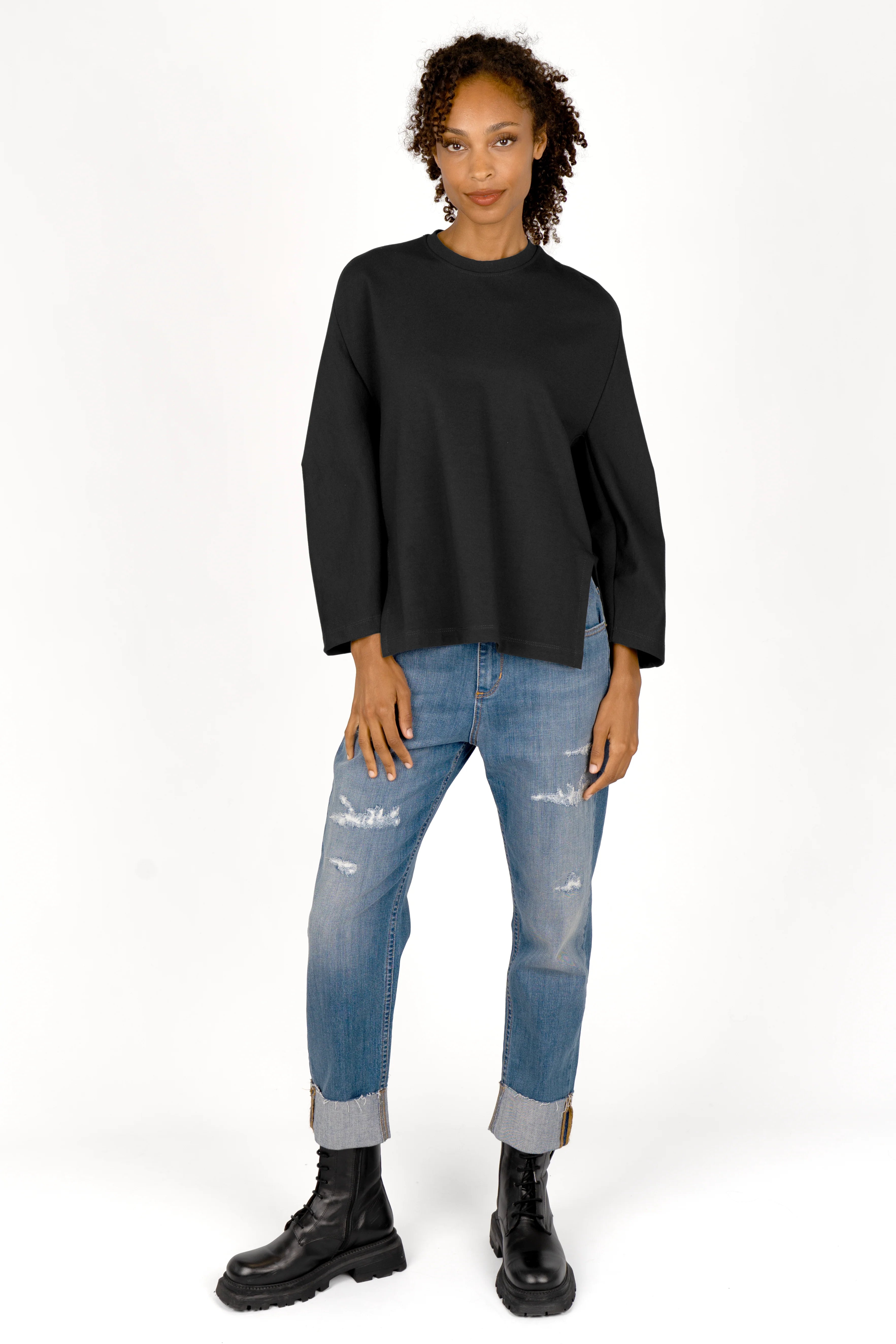 Relaxed fit TOOVE Shirt in black interlock jersey with curved seams, dropped shoulders, extended back, and high side slits.