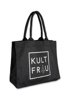 Eine schwarze Stofftasche aus festem Material, von der Seite fotografiert. Auf der Vorderseite befindet sich ein auffälliges, weißes Logo in einem quadratischen Rahmen mit dem Brandnamen "KULTFRAU" in Großbuchstaben. Die Tasche hat zwei lange, stabile Henkel aus dem gleichen Material, die an der Oberkante mit verstärkten Nähten befestigt sind. Sie wirkt geräumig und ist ideal für den täglichen Gebrauch oder zum Einkaufen.