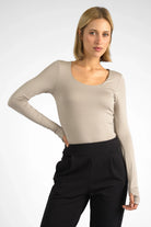 Woman wearing beige VALUM Longsleeve with U-boat neckline and thumbhole sleeves in slim fit style