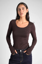 Woman wearing slim fit VALUM Longsleeve with U-boat neckline and thumb hole sleeves in dark brown