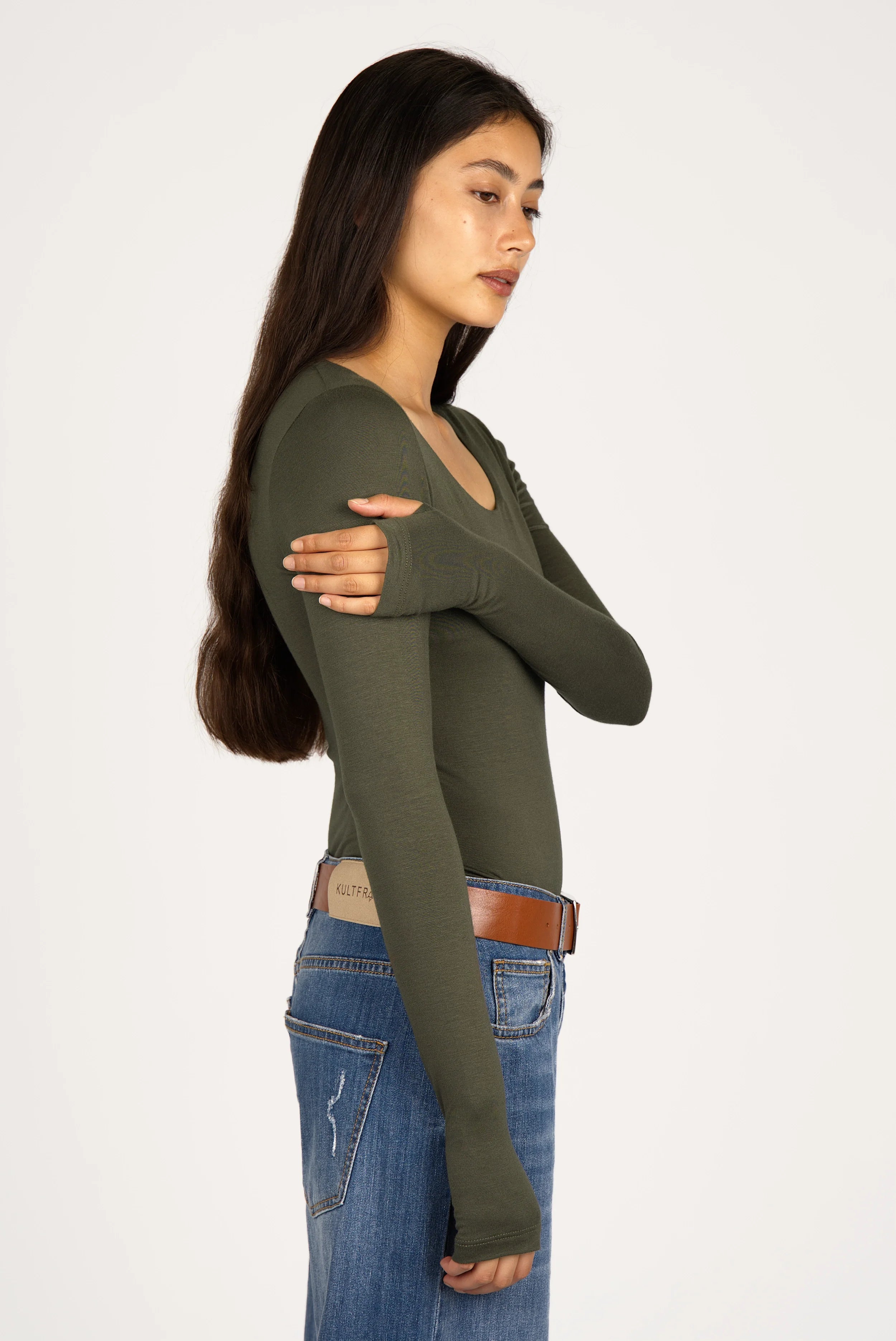 Woman wearing slim fit olive green VALUM Longsleeve with U-boat neckline and thumbholes in sleeves
