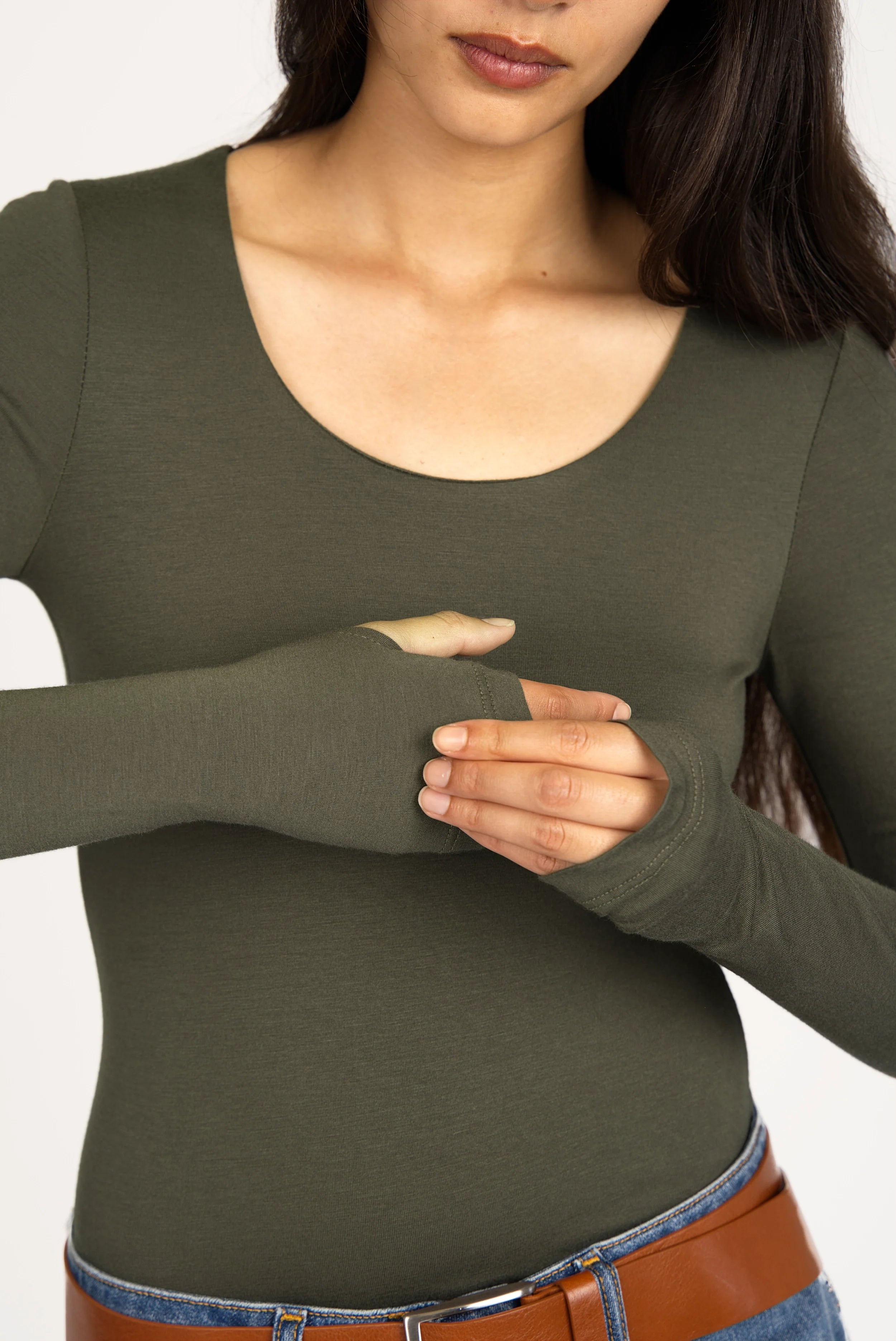 Woman wearing olive green VALUM Longsleeve with U-boat neckline and thumb holes in extended sleeves