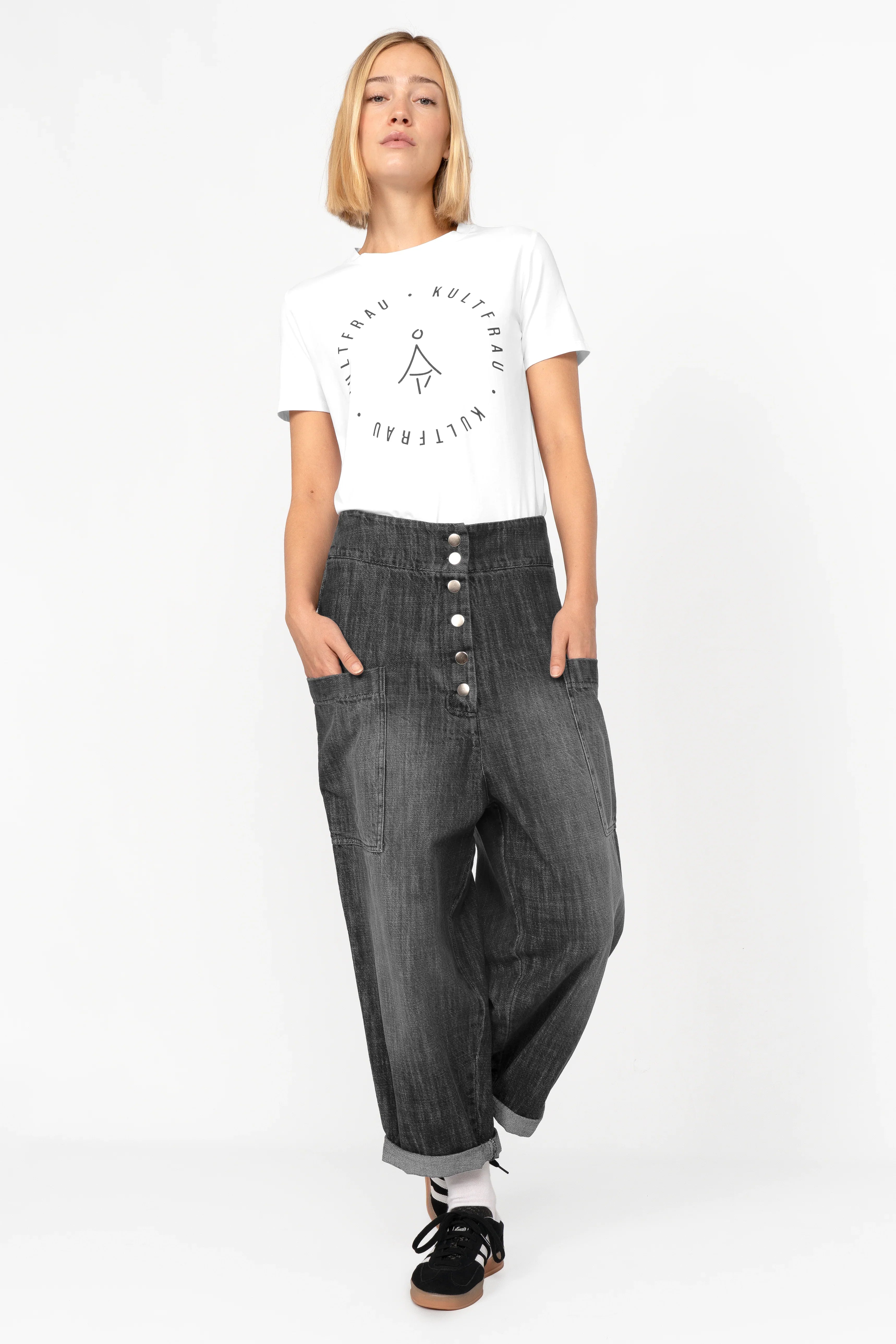 Woman wearing VIKADA Revive Baggy Hose in gradient wash denim with button fly and large side pockets.