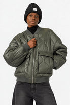 LARNA Padded Winter-Bomberjacke in Green Frost, Vorderansicht am Model mit JEANY Baggy Jeans in Faded Black.