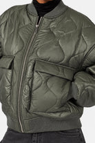 LARNA Padded Winter-Bomberjacke in Green Frost, Detailaufnahme von Steppung, Pattentasche, Reißverschluss und Rippbündchen.