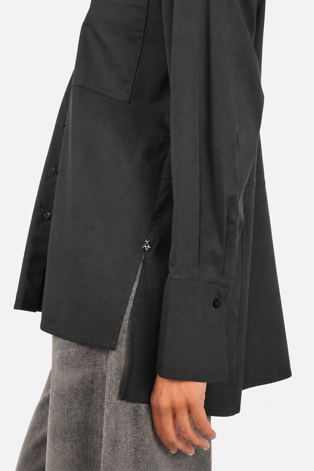 LEA.K Loose Fit Bluse in Schwarz, Detail von Manschette, Seitenschlitz und Logoanhänger mit JEANY Moonlight